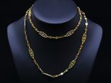 un ensemble composé d'un collier et d'un bracelet en or, présenté sur un mannequin