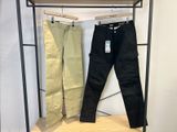 deux pantalons pour homme suspendus à un portant dans un magasin de vêtements