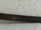 a very large knife that is hanging on the wall