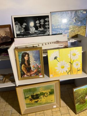 de nombreux tableaux exposés sur une étagère dans une pièce