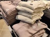 a lot of folded shirts on a shelf in a store