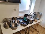de nombreuses casseroles et poêles posées sur une table dans la cuisine