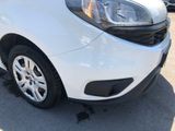 the front end of a white car parked in a parking lot