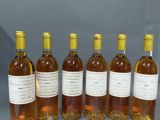 six bouteilles de vin sont alignées sur une table