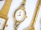 three watches and a bracelet on a white surface