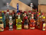 many bottles of alcohol on a table with a red table cloth