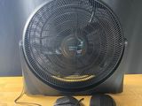 un ventilateur noir posé sur une table en bois, à côté de deux souris