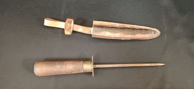 paire de couteaux anciens à manche en bois posés sur un fond noir