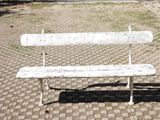 a white bench sitting on a cobblestone street
