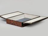 an old wooden box with a blue and white stripe inside
