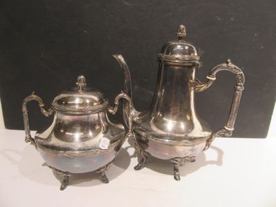 two silver teapots sitting next to each other on a table