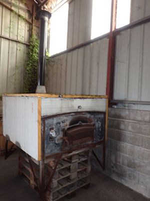 a small oven sitting in a building with a lot of windows