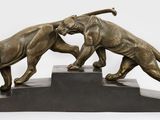 sculpture en bronze représentant deux lions se battant l'un contre l'autre, posée sur un socle en marbre