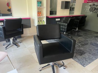 une chaise noire placée au milieu d'un salon