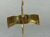 an old brass plate with a clock on it on a stand
