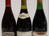 three bottles of wine are lined up on a white surface