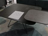une table sur laquelle est posé un dessin, avec un canapé en arrière-plan
