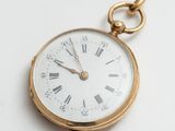 une montre de poche en or avec des chiffres romains