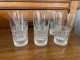 quatre verres sont alignés sur une table devant une commode