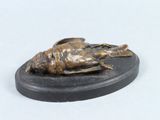 a bronze statue of a dead bird on a black base