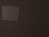 someone is writing on a piece of paper on a black surface