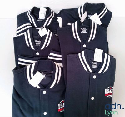 three men ' s baseball uniforms are lined up on a white surface