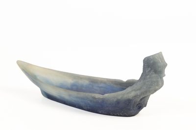 un objet en forme de bateau, bleu et blanc, posé sur une surface blanche