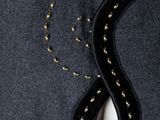 a close up of a mannequin wearing a black dress with gold beads on it