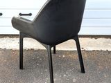 a black chair sitting in front of a garage door