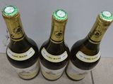 three bottles of wine that are sitting on the floor