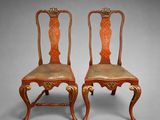 pair of antique chairs with carved wood and leather upholstered seats