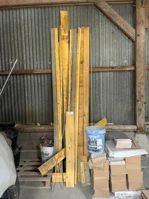 un tas de bois dans un garage, avec des cartons par terre