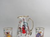 trois verres et un pichet posés sur une table