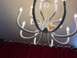 a chandelier made of white wires and a red curtain