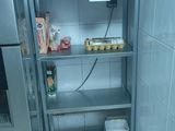 un réfrigérateur argenté et une étagère en métal dans une cuisine