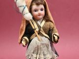 a doll that is holding a doll on a pink surface