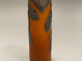 an orange vase with a design on the outside of it