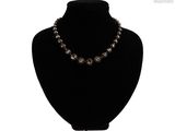 collier de perles noires présenté sur un mannequin devant un fond blanc