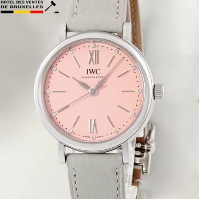a pink watch with roman numerals on the face