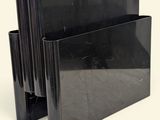un porte-livre noir posé sur une surface blanche