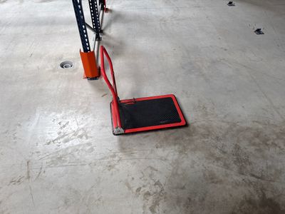 a red platform on the floor in a garage