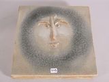 a ceramic box with a face painted on it