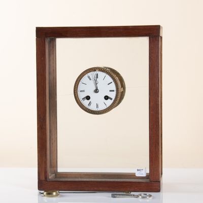 a small wooden clock sitting on a white table
