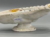 a white bowl with a yellow flower inside of it