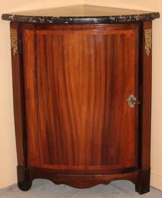a corner cabinet with a marble top in the corner