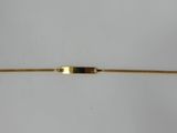 a close up of a gold bracelet with an arrow on it