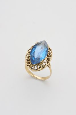 une bague en or sertie d'une topaze bleue au centre