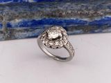 un gros plan d'une bague en diamant posée sur une pierre bleue