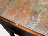 a close up of a wooden table with a blue tag on it