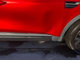 a close up of a red car parked in a parking lot
